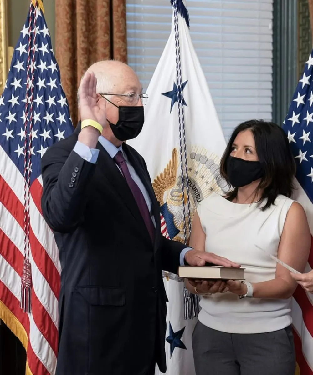 Ken Salazar with his right hand raised, taking the oath of office as Ambassador