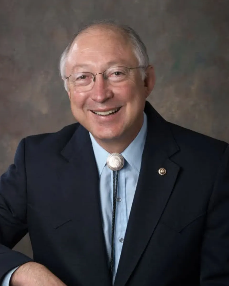 Official portrait of Ken Salazar in a dark jacket and bolo tie
